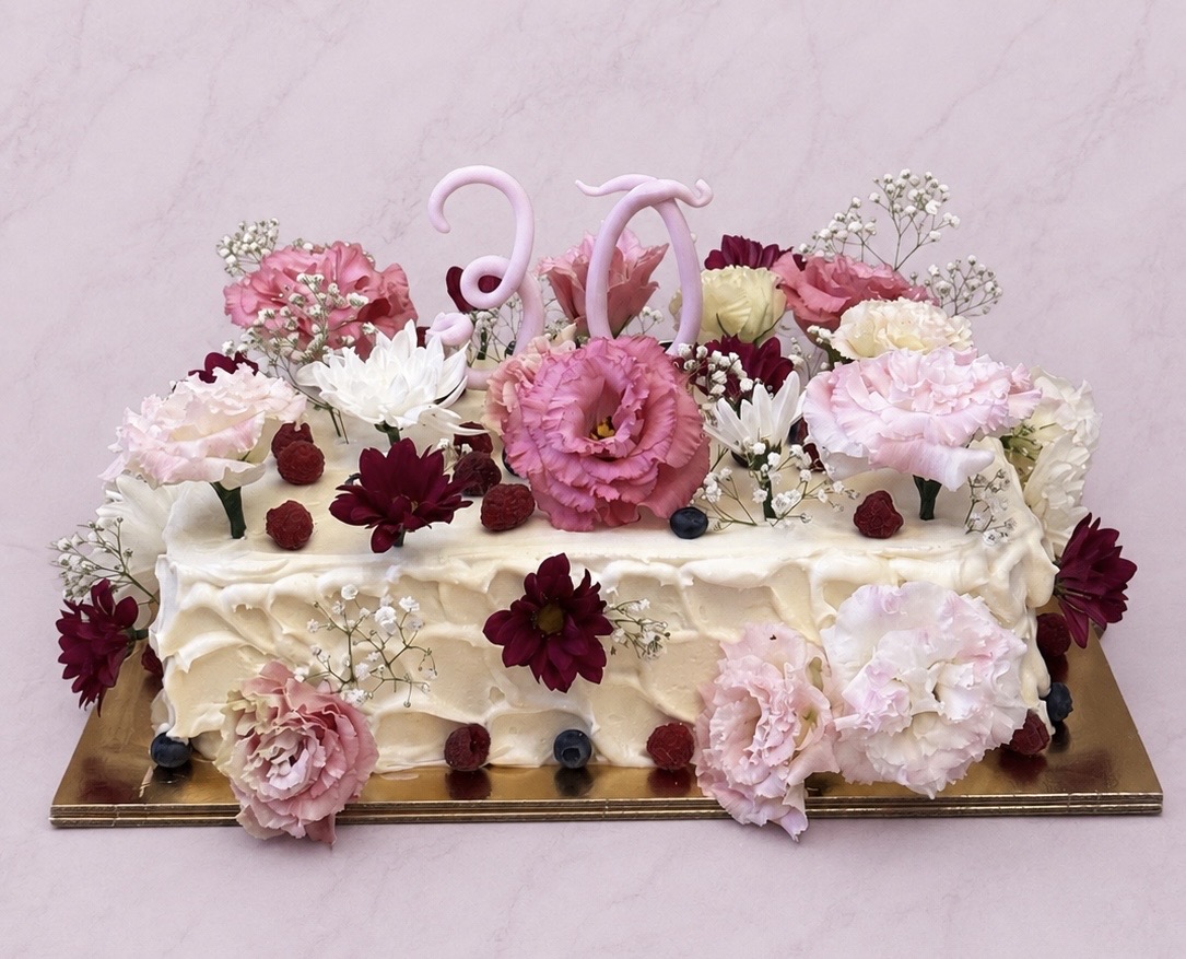 Élővirágokkal és bogyós gyümölcsökkel díszített szülinapi torta