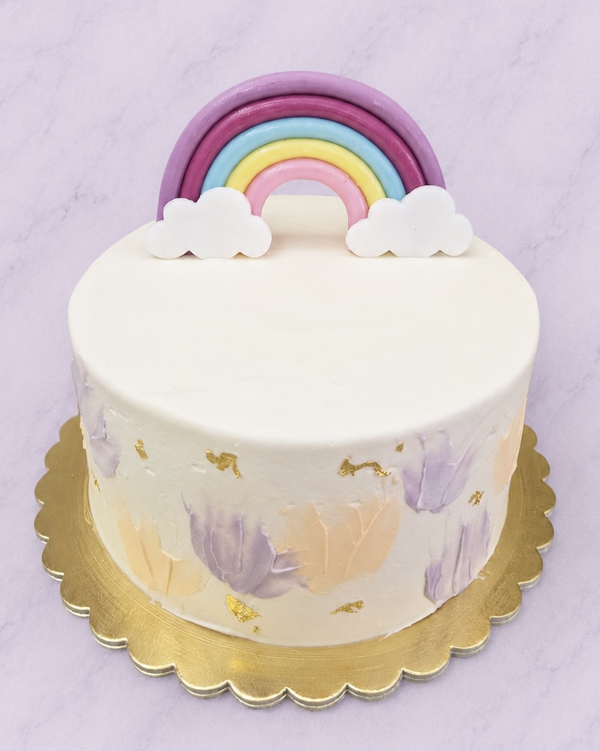 Fehér torta pasztell szivárvánnyal és felhőkkel